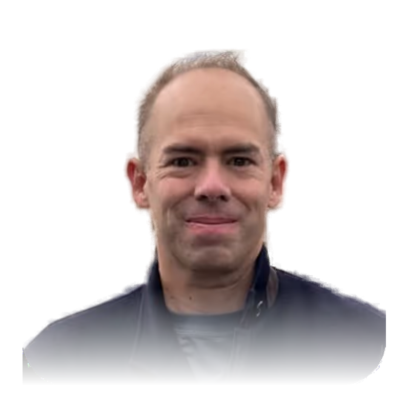 Portrait of Ross Overstreet, smiling, with short light brown hair and a dark jacket